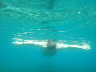 Naklejka premium Man swimming under water into the sea