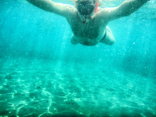 Obraz na płótnie Canvas Man swimming under water into the sea