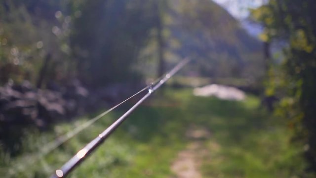Walking with a fishing rod in the hand (POV)