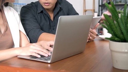 Two workers are working together at cafe.