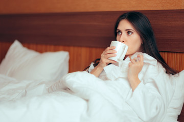 Sick Woman Drinking Tea Holding Paper Tissues in Bed