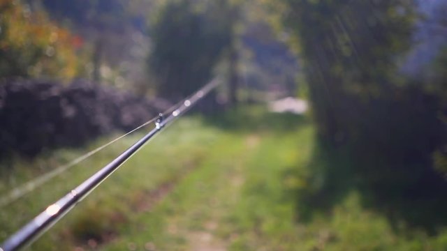 Walking with a fishing rod in the hand (slow motion POV)