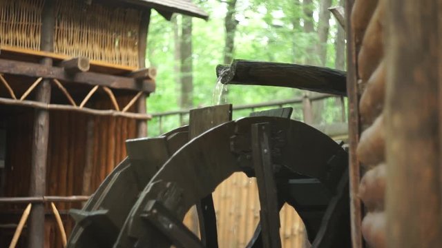The mill wheel rotates under a stream of water