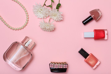 Women cosmetics with flowers on a pink background.