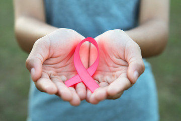 woman hand holding pink ribbon breast cancer awareness. concept healthcare