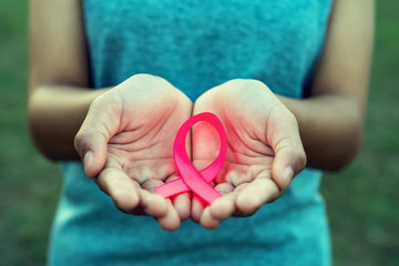 woman hand holding pink ribbon breast cancer awareness. concept healthcare