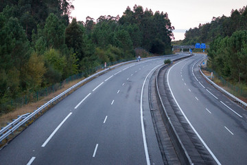 Wide empty highway with curve in the morning. Travel and destination background. Free asphalt road with mountain background. Motion and speed concept. Trip and journey concept. Driving concept.