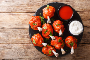 Delicious Deep frying Lollipops chicken wings with sauces close-up on a slate board. horizontal top...