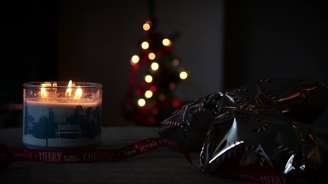 Burning Candle with christmas tree in background