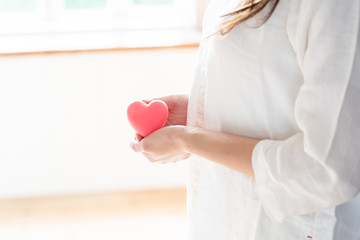 young asian woman holding heart symbol