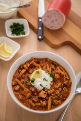 Typische DDR Soljanka Suppe in Schale mit Schmand und Zitrone