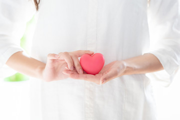 young asian woman holding heart symbol