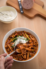 Frau isst typische DDR Soljanka Suppe in Schale mit Schmand und Zitrone