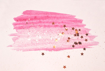 Golden glitter and glittering stars on abstract pink watercolor splash in vintage nostalgic colors.