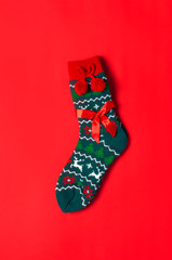 Woolen socks with a Christmas New Year ornament on red background top view flat lay. Holiday concept, Festive socks, presents Xmas. Congratulations background with space for text. Clothes for the cold