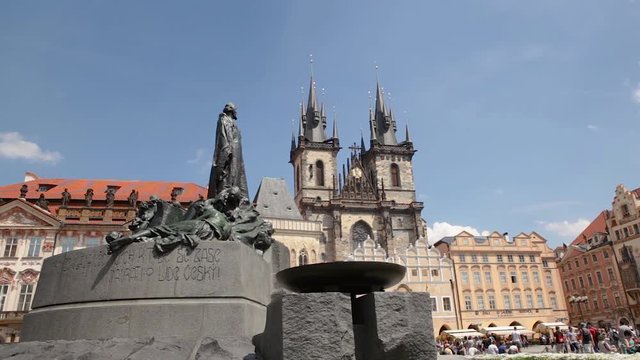 Travel Prague, Czech Republic - Iconic sculpture Jan Hus monument with the church of our lady before Tyn in the background, city center