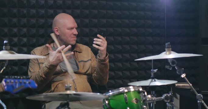 Middle-aged musician twirling drumstick in one hand