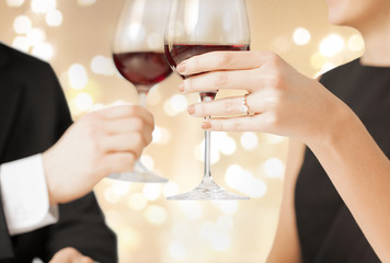 valentines day, celebration and engagement concept - close up of couple hands clinking champagne glasses
