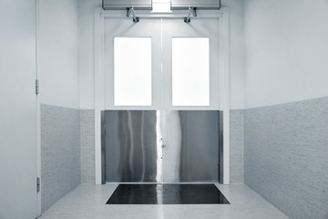medicine, health care, emergency and interior concept - steel doors in hospital corridor