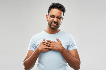 people, heart disease and health problem concept - unhappy indian man suffering from heartache over...