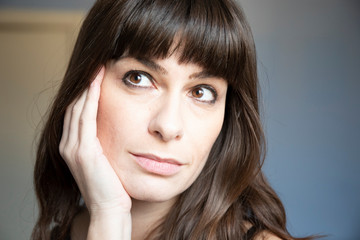Fototapeta premium Young woman close-up portrait. Caucasian with brown long hair and bangs.