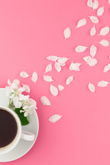 Flat lay of coffee and white flowers petals