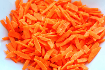 Cook dishes with carrots. Cut carrots in a frying pan.
