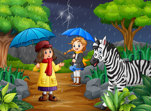 Two girl carrying umbrella goes under a rain with zebra