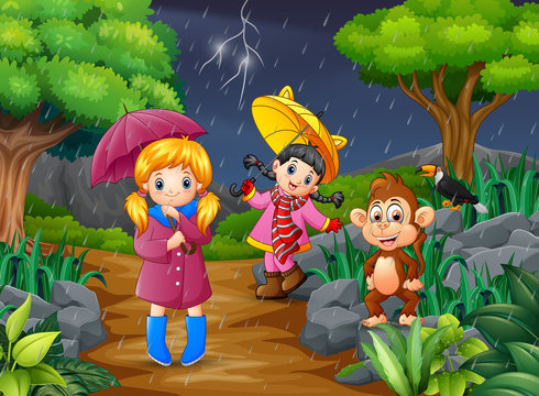Two girl carrying umbrella goes under a rain with monkey