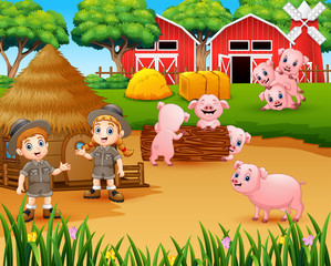 Obraz na płótnie Canvas Zookeeper girl and boy with pigs in the farmyard