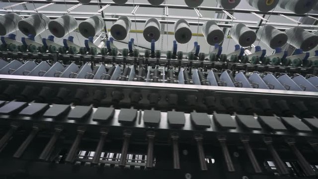 Spinning factory, production of fabrics, thread of silk, linen, and synthetics, view of spools of thread, automated process on light industry.