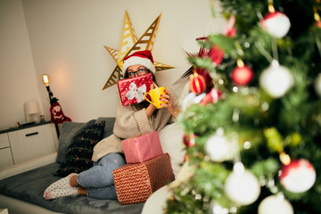 Beautiful woman with Santa hat using cellphone and enjoying Christmas eve/New Year.