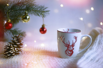 Cup with a deer on the background of the lights of Christmas garland