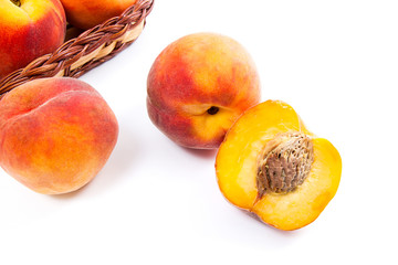 Naklejka na ściany i meble Whole and half of ripe peach fruit and several in basket isolated on white background.