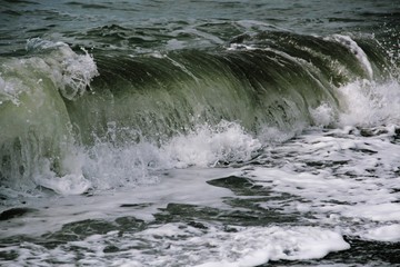 Wave foaming crashing on shore