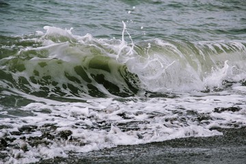 Wave foaming crashing on shore
