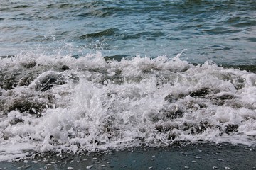 Wave foaming crashing on shore