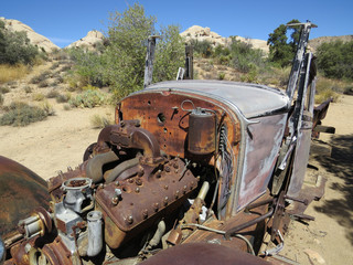 Old rusty car in the desert close in on engine