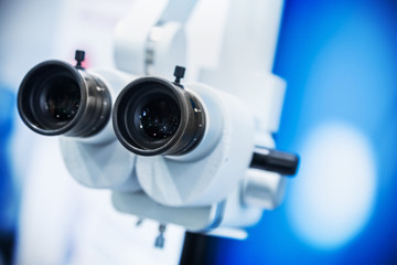 The eyepieces of the microscope are taken large on a blue background. focus on the frames of the microscope, shallow depth of field