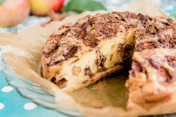 Homemade apple pie with cinnamon on grey wooden background.