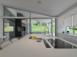 interiors shots of a modern white kitchen island in the villa with induction cooker and integrated...