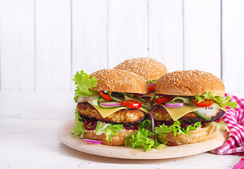 Tasty grilled homemade hamburger with burger chicken, tomato, cheese, cucumber, lettuce and...