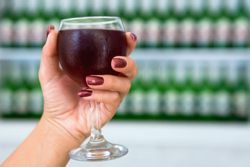 A glass of cool wine in an elegant female hand.