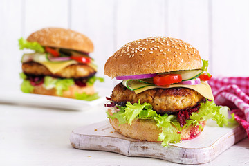 Tasty grilled homemade hamburger with burger chicken, tomato, cheese, cucumber, lettuce and beetroot. Sandwich. Lunch