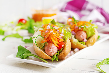 Hot dog with  cucumber, carrot, tomato and lettuce on wooden background. Fast food menu.