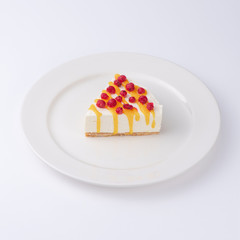 Cheesecake with mango sauce and fresh berries isolated on white background