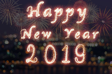 Happy new year 2019 written with Sparkle firework on fireworks with photo blurred of cityscape dark background, celebration and greeting cards concept