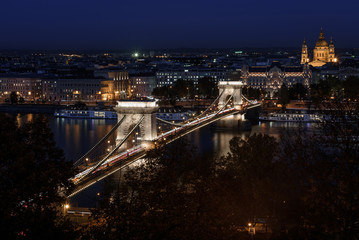 Fototapeta na wymiar Szechenyi chain bridge budapest, lit up at night time, with St. Stephen's Basilica, in the background