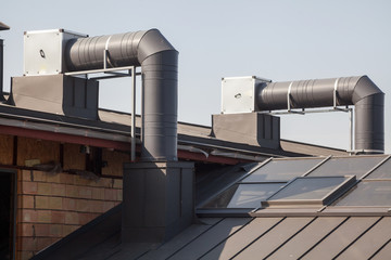 Air conditioning equipment atop a new metal roof of modern building