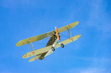 a green old plane flying in an air show